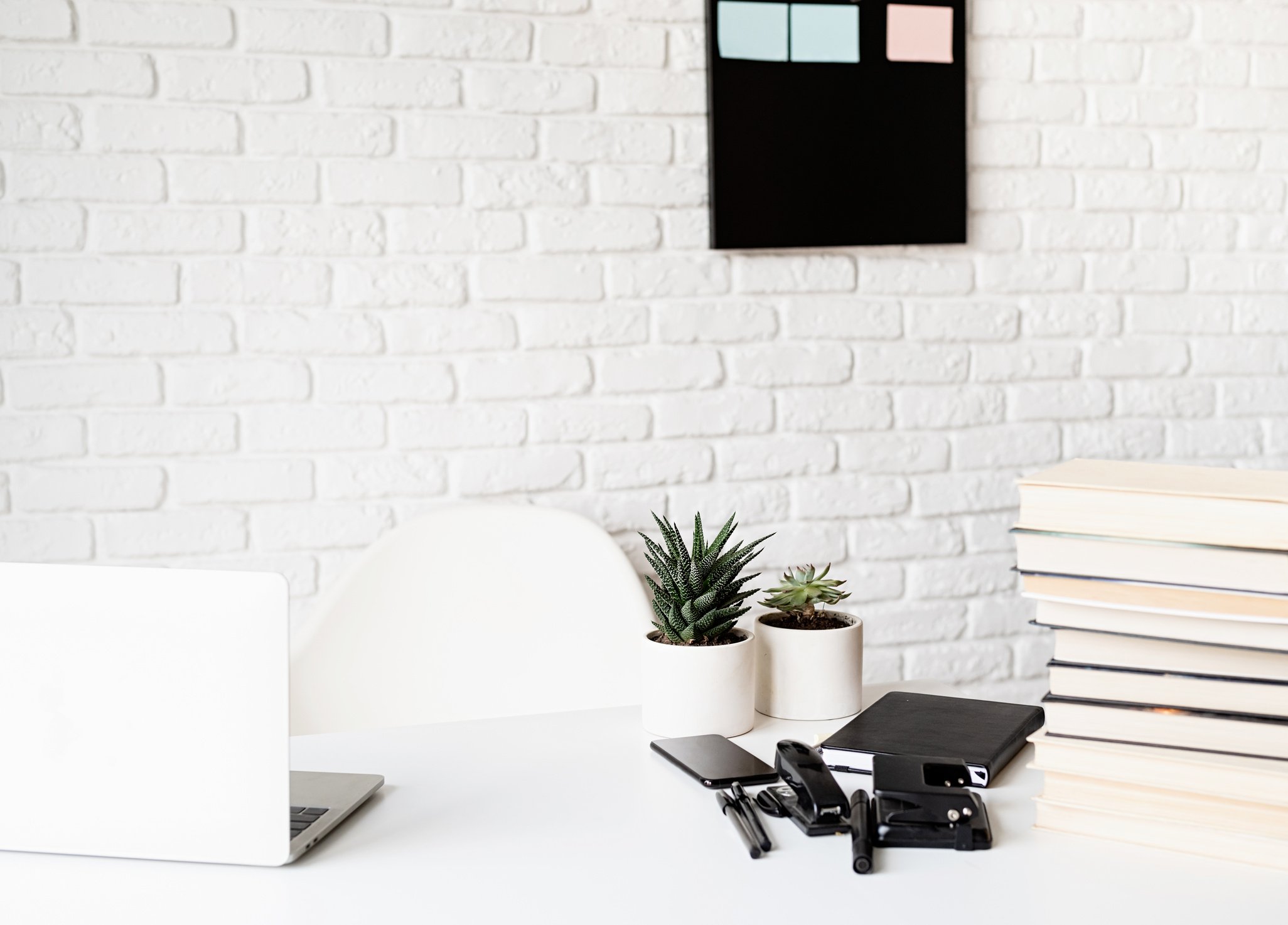 light and airy workspace, teacher table with laptop, books a